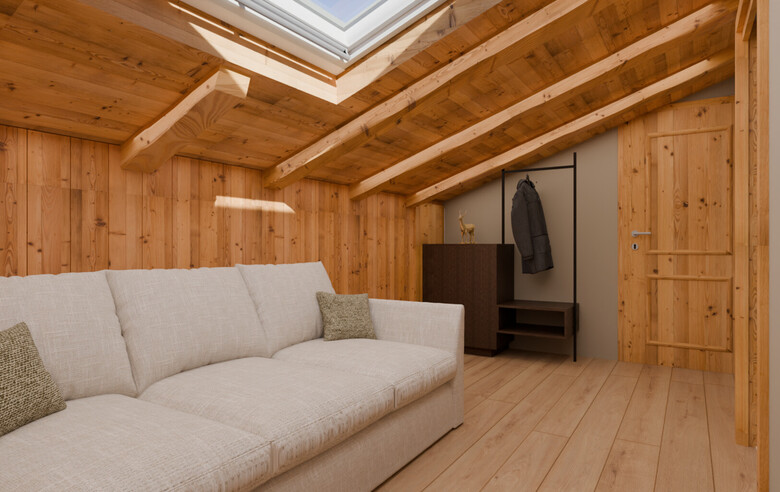 Gemütliches Zimmer mit schräger Holzdecke, Dachfenster, hellgrauem Sofa und Garderobe mit Jacke.