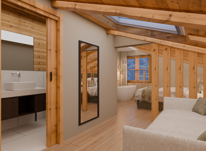 Zimmer mit Sofa, großem Spiegel, Holzbalkendecke und Blick in ein Badezimmer mit Waschbecken und in ein Schlafzimmer mit freistehender Badewanne.